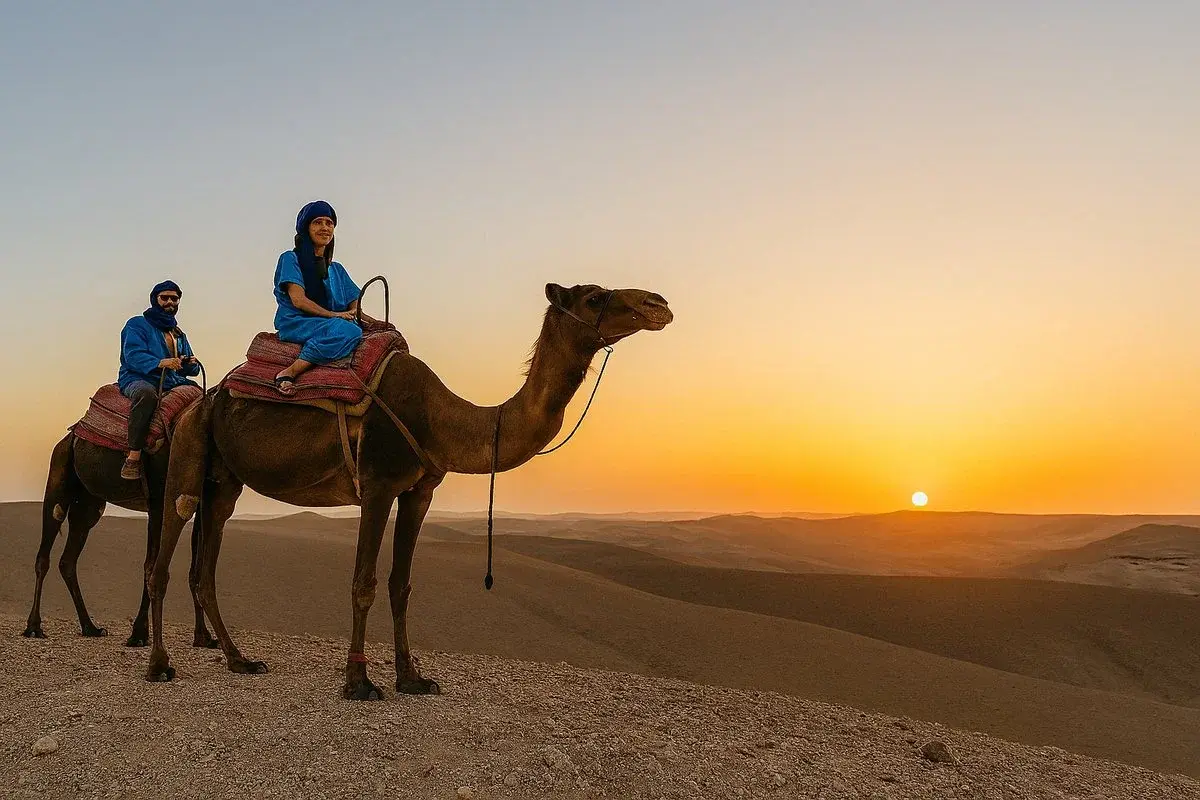 A couple riding a camel across the Agafay Desert at sunset