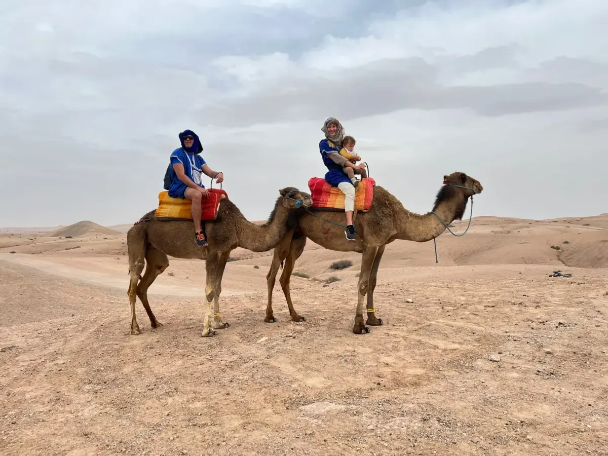 A family riding camels together in the Agafay Desert